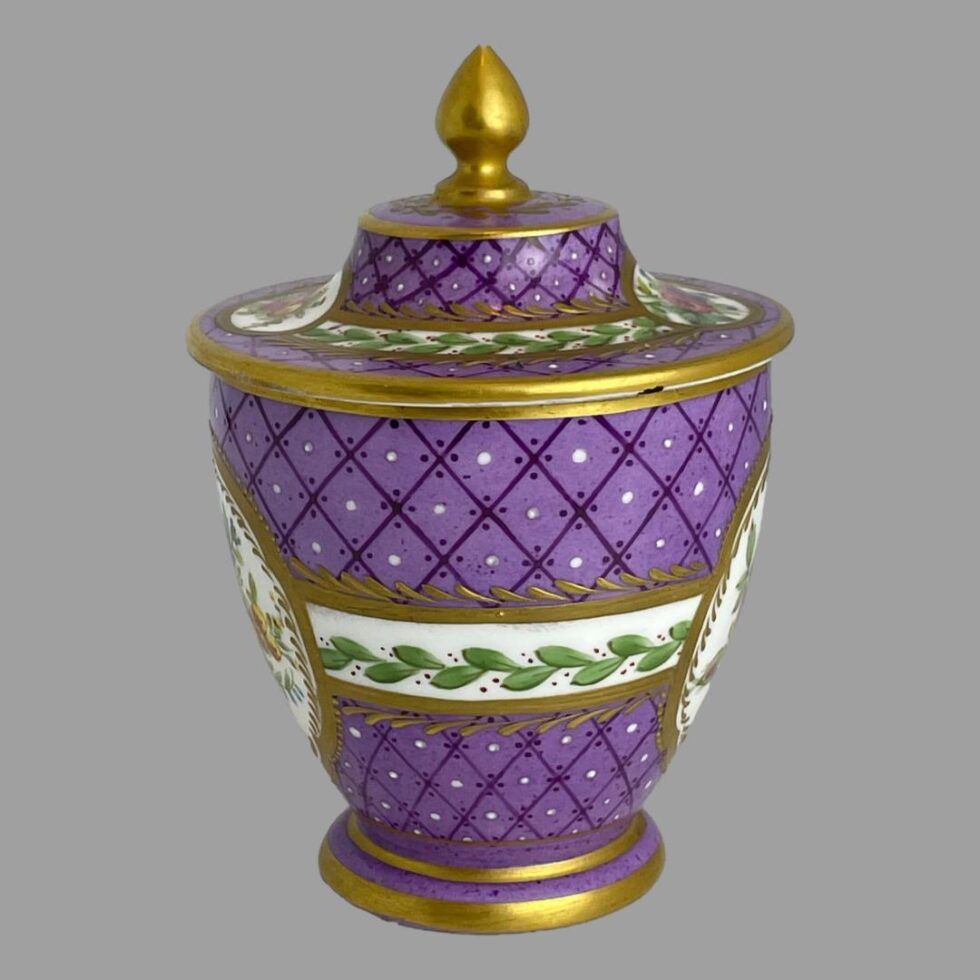 The 19th century lidded pot this time seen from a side angle showing the white band with foliage and berries on both pot and lid. The 'windows' of flowers is just visible to the extreme left and right.