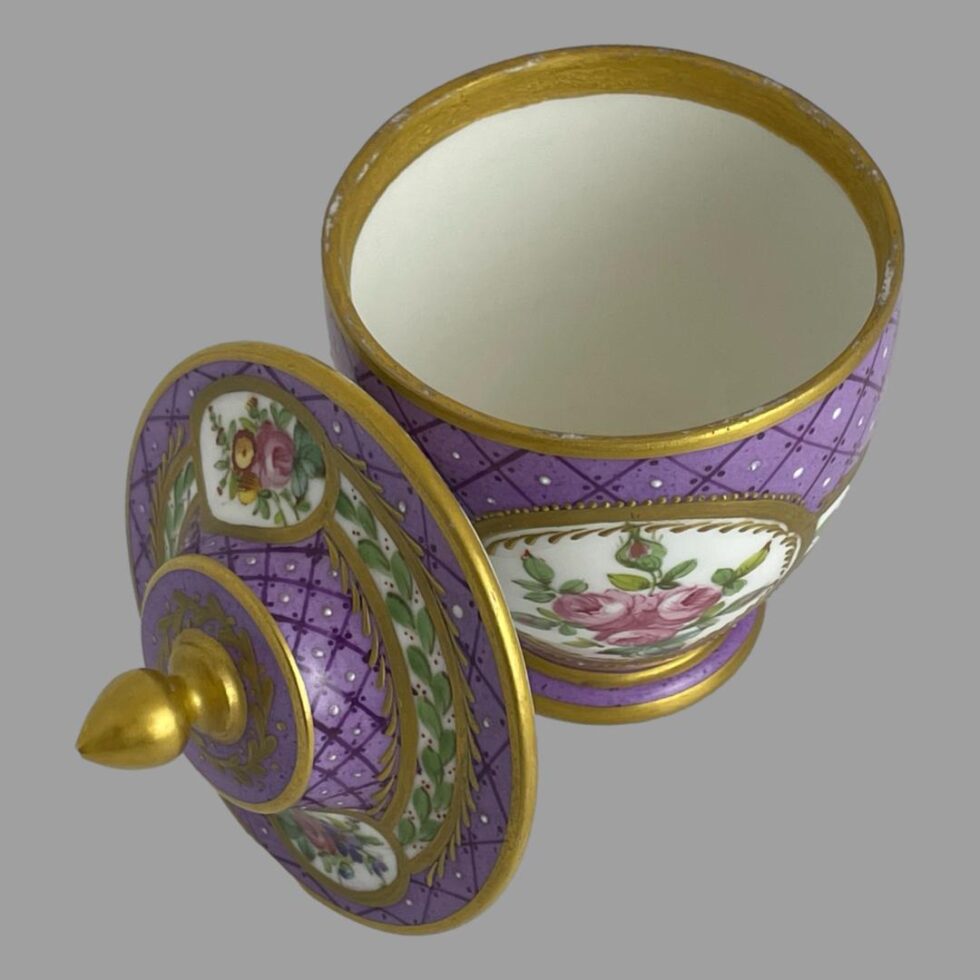 Photo of the 19th century pot with lid removed and propped up to the bottom left side of the base of pot. The interior and gilt work is in good condition.