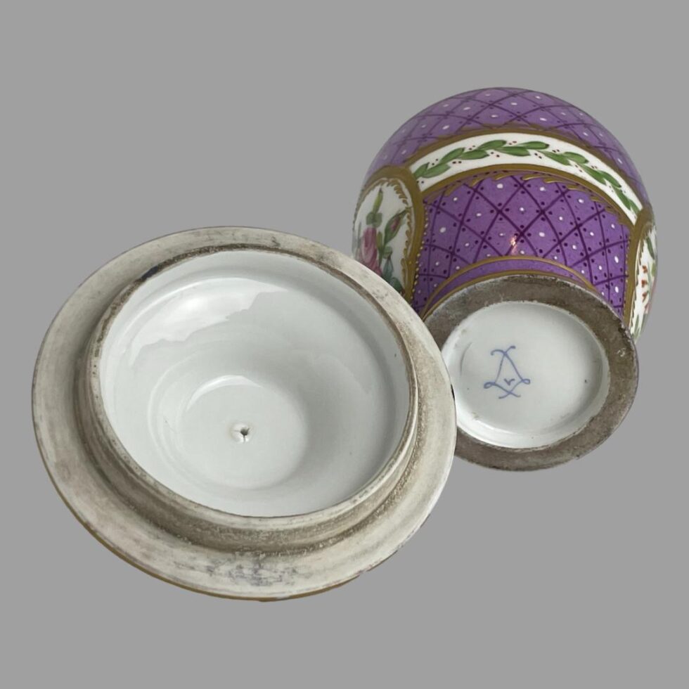 Photo of the base of the pot showing the Sèvres mark with the lid on the left with inside on display. The inside of the lid is glazed porcelain and clean whereas the outer rim that overhangs the base not glazed hence a little scruffy looking.