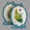 Main photo of pair Minton porcelain pictures displayed with one in front of the other and to the side. The front picture is of the ferns in various shades of green, orange and pink. A red butterfly can be seen top right and a ladybird bottom right of the ferns. The incredible work put into these pictures with the turquoise blue of the ribbon frame ending in a bow at the top and bottom is quite incredible. It is sometimes hard to fathom that these are made entirely of porcelain!