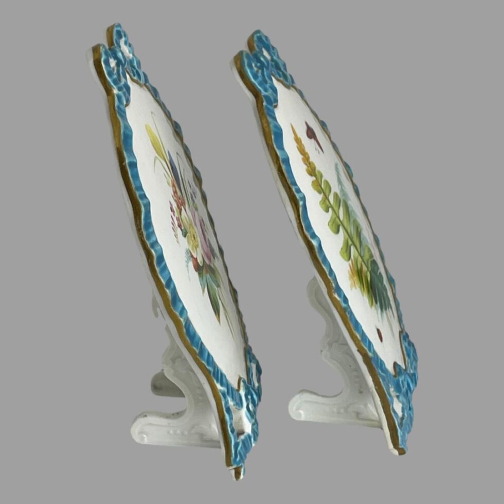 Photo of both porcelain pictures displayed from a side angle. The pictures have their own porcelain stands built in and to even out the weight distribution and balance, the pictures are set leaning back at the top like a photo frame.