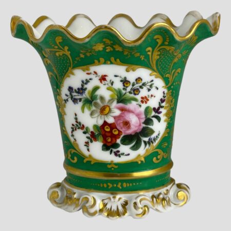 Main photo of Pairs scallop edged vase displayed with the decorative floral window side on show. The base colour of the vase is quite a breath taking shade of green - could be called green turquoise. The 'window' with flowers has a white background and there is a mixed bunch of flowers here in pink, blue, red, yellow and purple. Lovely gilt work extends over all the green turquoise area with dots and swirls. The base is white and moulded shape like sea froth with some gilt work. The top of the vase flutes outward with scalloped edge. The vase is in lovely condition but for the gilt wear around the rim which is quite extensive but could easily be touched up by someone with steady hands. Very pretty vase with or without flowers.