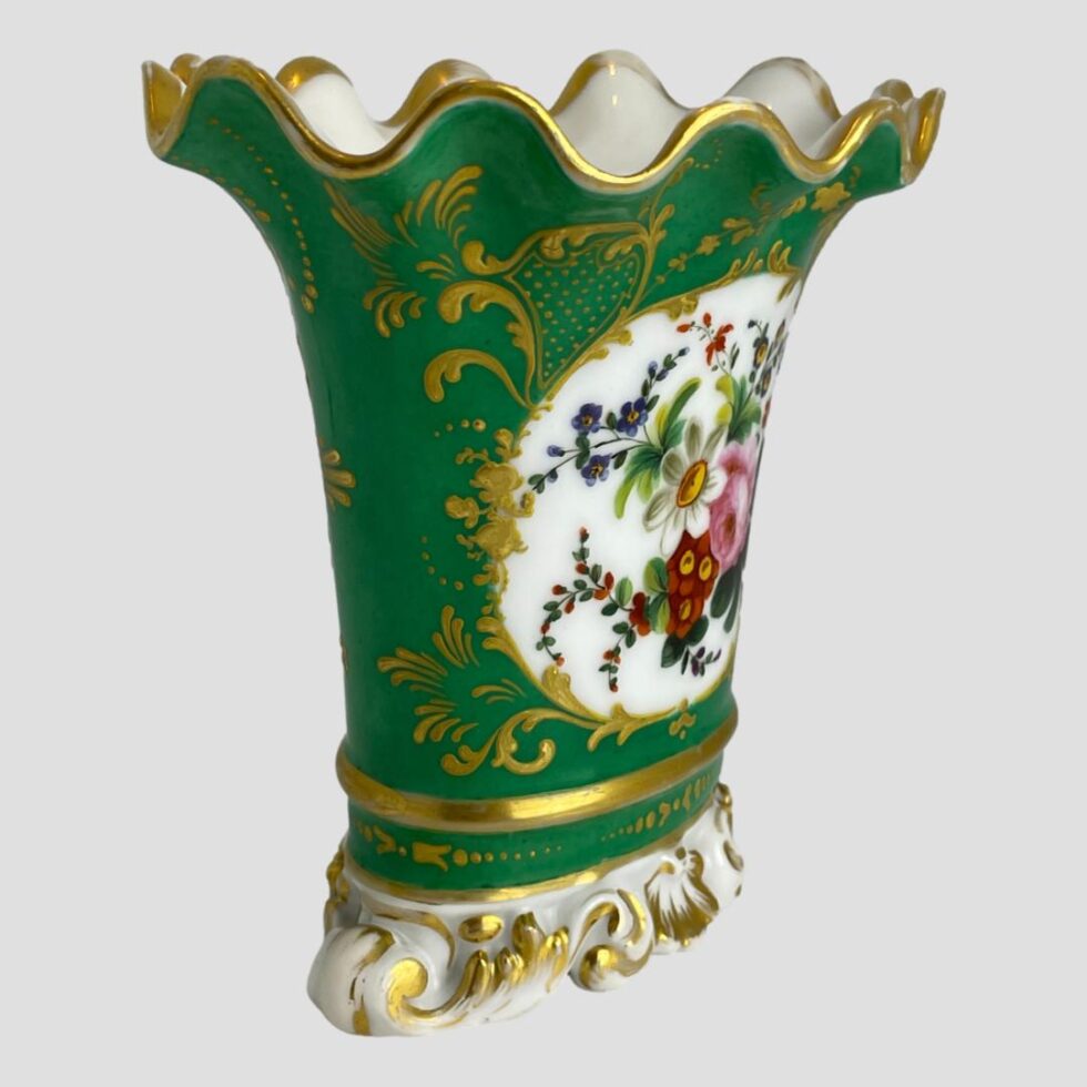 Photo of scallop edged vase this time displayed at a slight angle with the floral image side facing towards the bottom right corner.