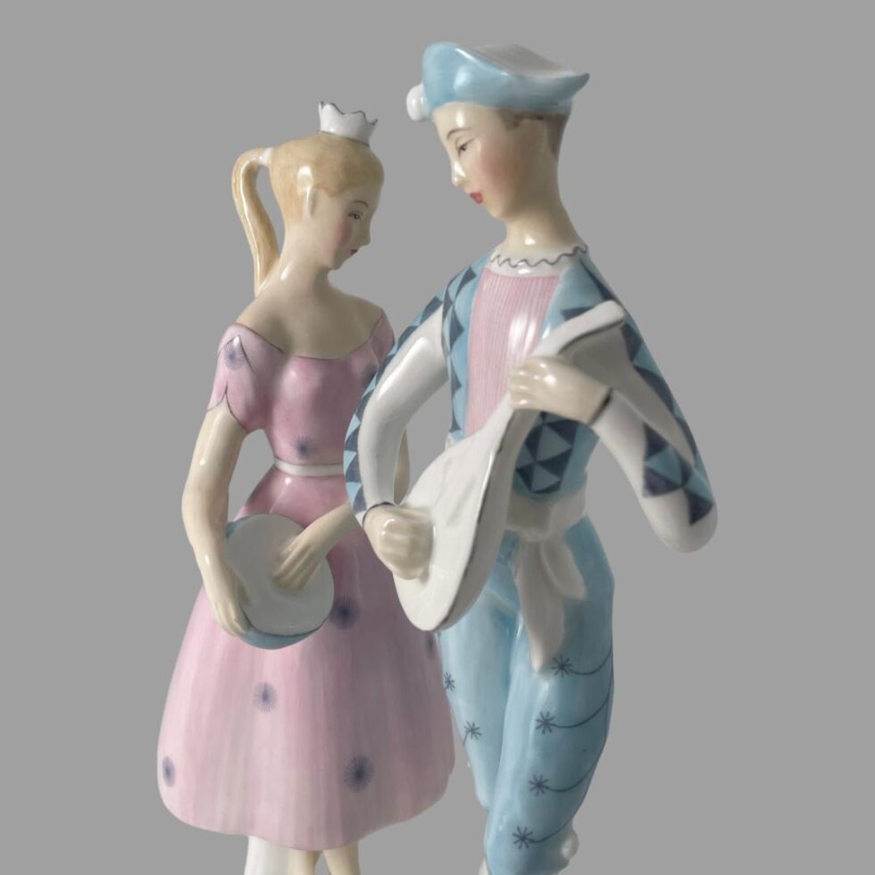 A close up of the upper parts of the figurines this time with Harlequin in the foreground and to the right. Columbine is to the back and left. Posed like this, the 2 figurines are facing each other but their gaze is lowered to the ground. They both do have a dreamy expression on their faces.