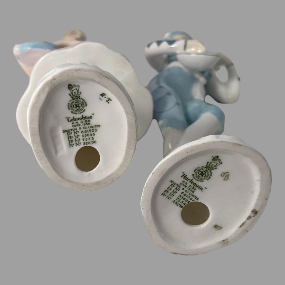 A photo of the base of both figurines showing the makers mark and figurine name.