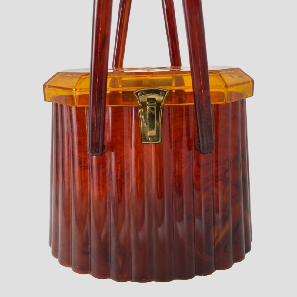 A close up photo of the front of the acetate bag with the fan shaped brass clasp clearly visible.