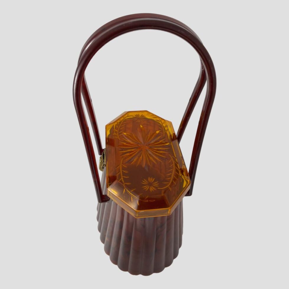 Photo of the 50s moulded bag looking from a side angle and diagonally down so the top of lid is fully shown. The handles are once again upright.