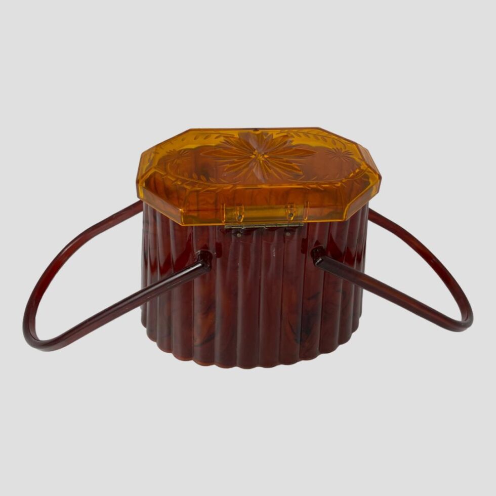 Photo of the back of the moulded acetate purse with the handles laid down to the left and right.