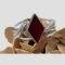 Main photo of red onyx silver cuff displayed on top of a rock of natural desert sand rose with the bracelet front forward facing. The red onyx has a deep rich red colour and is set with an outer frame of sterling silver. The diamond suit shape juts out at the top and bottom points of the diamond. Like the diamond suite in a pack of cards, it is longer vertically. The cuff has 3 silver lines which join at the cuff ends. The 2 silver feathers, one on each side of the red onyx, sit top to tail to each other. One the left, the tip of the feather leans alongside the top lean of the onyx diamond shape and to the right, the feather tip leans alongside the lower lean of diamond shape. The ends of those feathers curl slightly outward and attaches onto the opposite silver band.