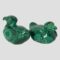 Main photo of pair of malachite ducks shown side by side with one on left facing away from camera towards the top left corner and one on the right facing towards bottom right corner. They are side by side and top to tail and displayed diagonally.