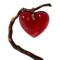 Main photo of signed Baccarat heart pendant displayed hanging from a thin twig with the front of pendant forward facing. The crystal heart is a beautiful shade of red - truly the colour of love with a gold tine bail. The heart front is rounded whereas the back is flat and there are 2 ridges carved into it giving more depth. A fabulous gift item.