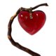 Main photo of signed Baccarat heart pendant displayed hanging from a thin twig with the front of pendant forward facing. The crystal heart is a beautiful shade of red - truly the colour of love with a gold tine bail. The heart front is rounded whereas the back is flat and there are 2 ridges carved into it giving more depth. A fabulous gift item.