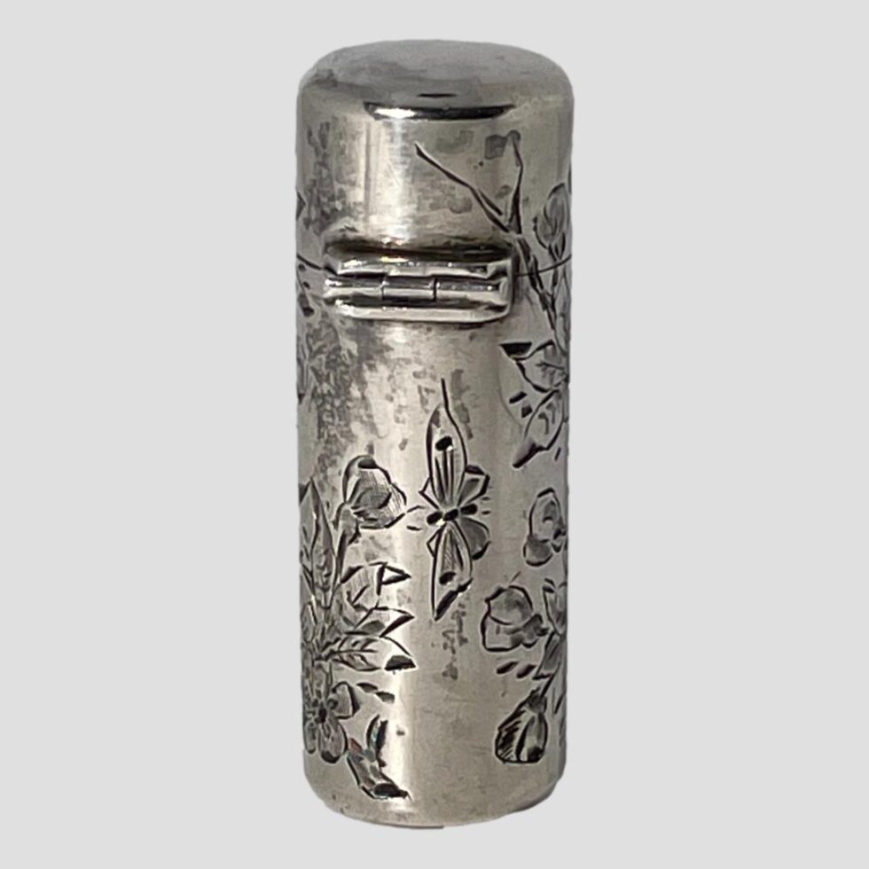 Photo of the back of the scent bottle showing the sturdy hinge to the lid and a larger butterfly engraved on the body of the bottle. This must be what the second bird was looking at!