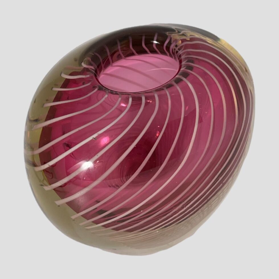Photo of Vicke Lindstrand vase again from a slightly raised angle with one wider side of the vase facing the bottom right corner.