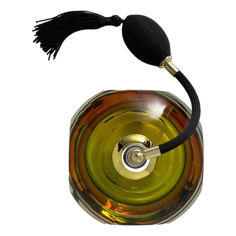 Photo looking straight down at the Murano perfume atomiser from above. The 4 flat and 4 rounded shape of the squat glass bottle is clearly visible. The spray atomiser is at the top half of the photo while the squat glass bottle is in the bottom half.