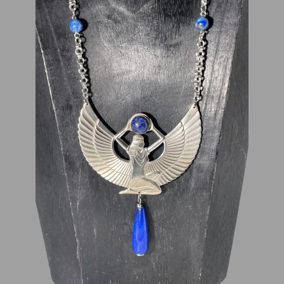Close up photo of the goddess Isis area of the necklace showing in detail the pose of the goddess. The small lapis beads on the chain and the waterdrop shaped one below are a brighter more vibrant shade whereas the one she holds above her head is a darker shade of blue.