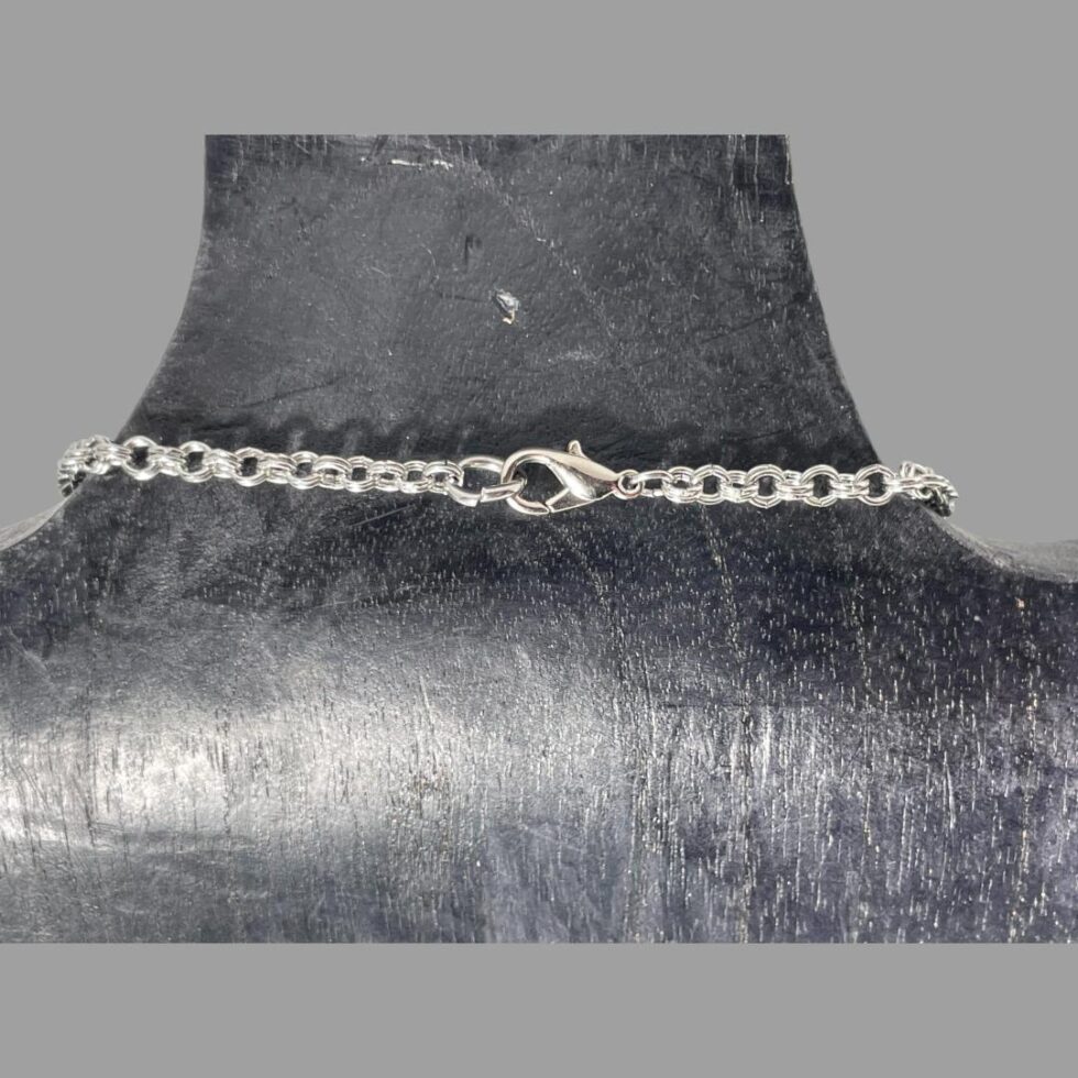 Photo of the clasp area of the necklace still displayed on the black wooden display stand. The clasp is a lobster type.
