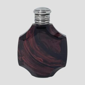 Main photo of antique French scent bottle displayed with the front opening side on display. The glass bottle shape is an octagonal shape with slight dips to the 4 sides at 10, 2, 4 and 8 o'clock. The glass is a chocolate cherry colour with swirls and lines simulating agate or even marble in a lighter chocolate cherry shade. The silver top is hinged with no obvious markers for the opening (just about halfway down!)