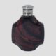 Main photo of antique French scent bottle displayed with the front opening side on display. The glass bottle shape is an octagonal shape with slight dips to the 4 sides at 10, 2, 4 and 8 o'clock. The glass is a chocolate cherry colour with swirls and lines simulating agate or even marble in a lighter chocolate cherry shade. The silver top is hinged with no obvious markers for the opening (just about halfway down!)