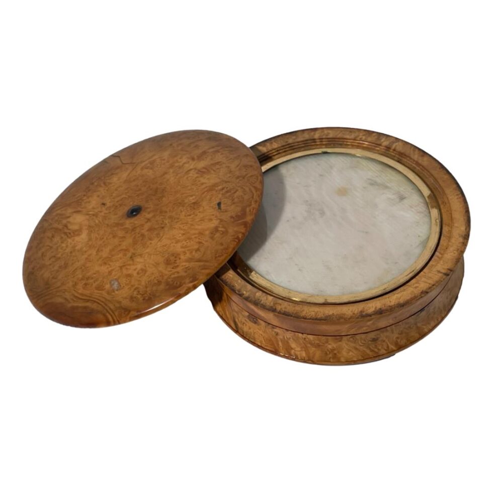 Photo of the turned beechwood snuff box this time with the lid removed and placed leaning to the left of the rest of box. The glass disc with lining is now on display.