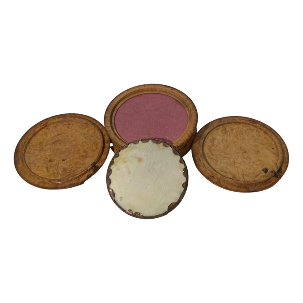 Photo of turned birchwood snuff box displaying the underside of the lid and base, the glass disc and the underside of the last compartment which is lined with pink card (?)