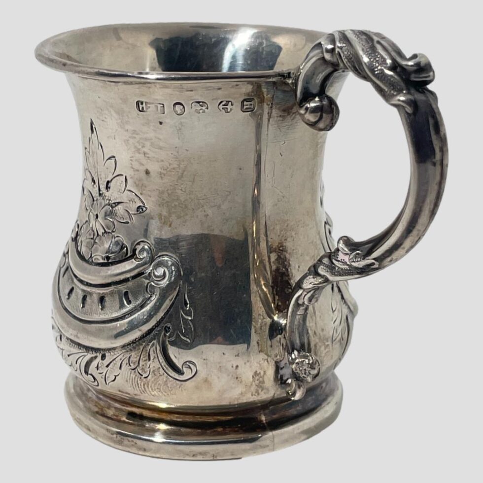 Photo of Victorian silver cup turned slightly round to the right so the hallmark which is left of the handle top is fully visible.