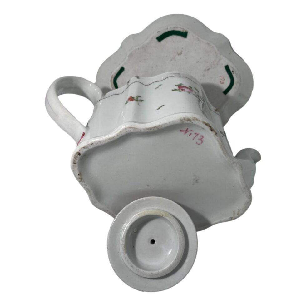 Photo of the underside of all 3 pieces showing no makers mark just number 173 on stand and teapot.