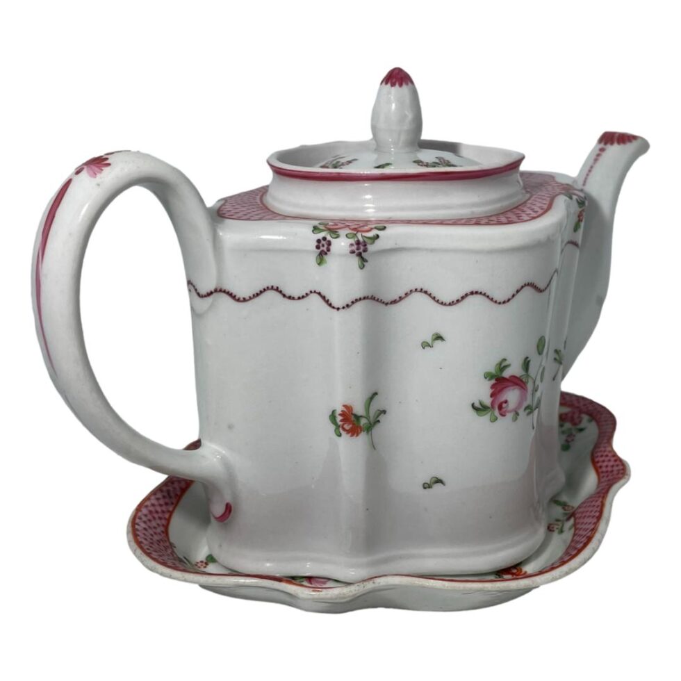 Photo of New Hall teapot on its stand this time with the handle in the bottom left corner of photo and the spout in top right corner.