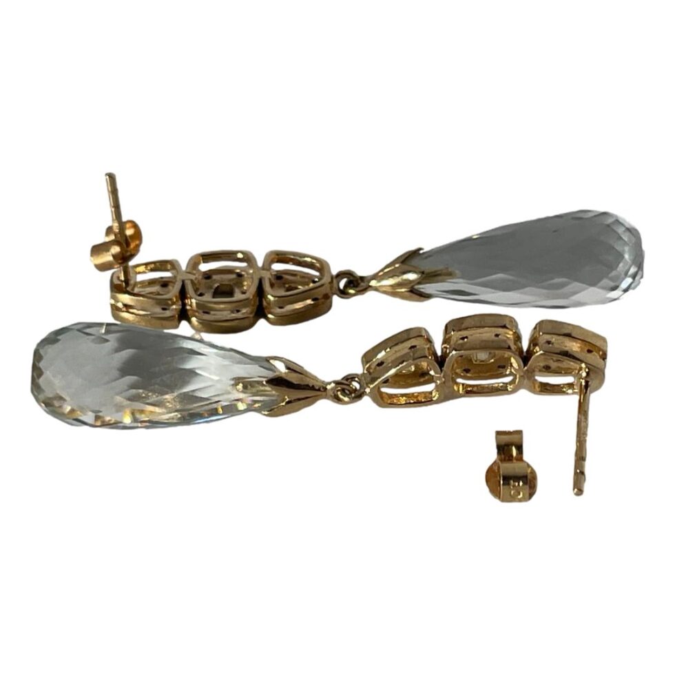 Photo of both earrings laid head to tail horizontally on a plain white surface. The earring in the foreground has its butterfly fastener removed and placed face down just displaying the hallmark. The triple sectioned column structure is clearly visible here.