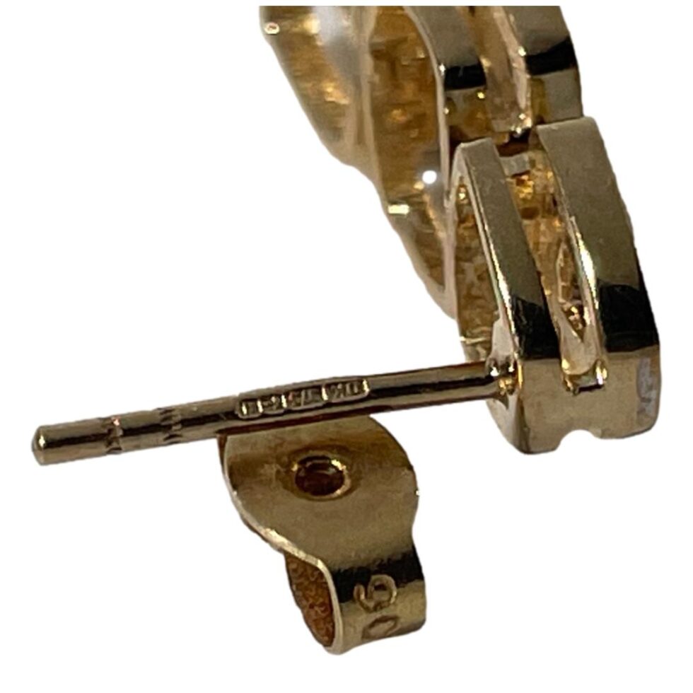A close up photo of the post of one of the earrings showing the full hallmark as well as part of the hallmark on the butterfly.