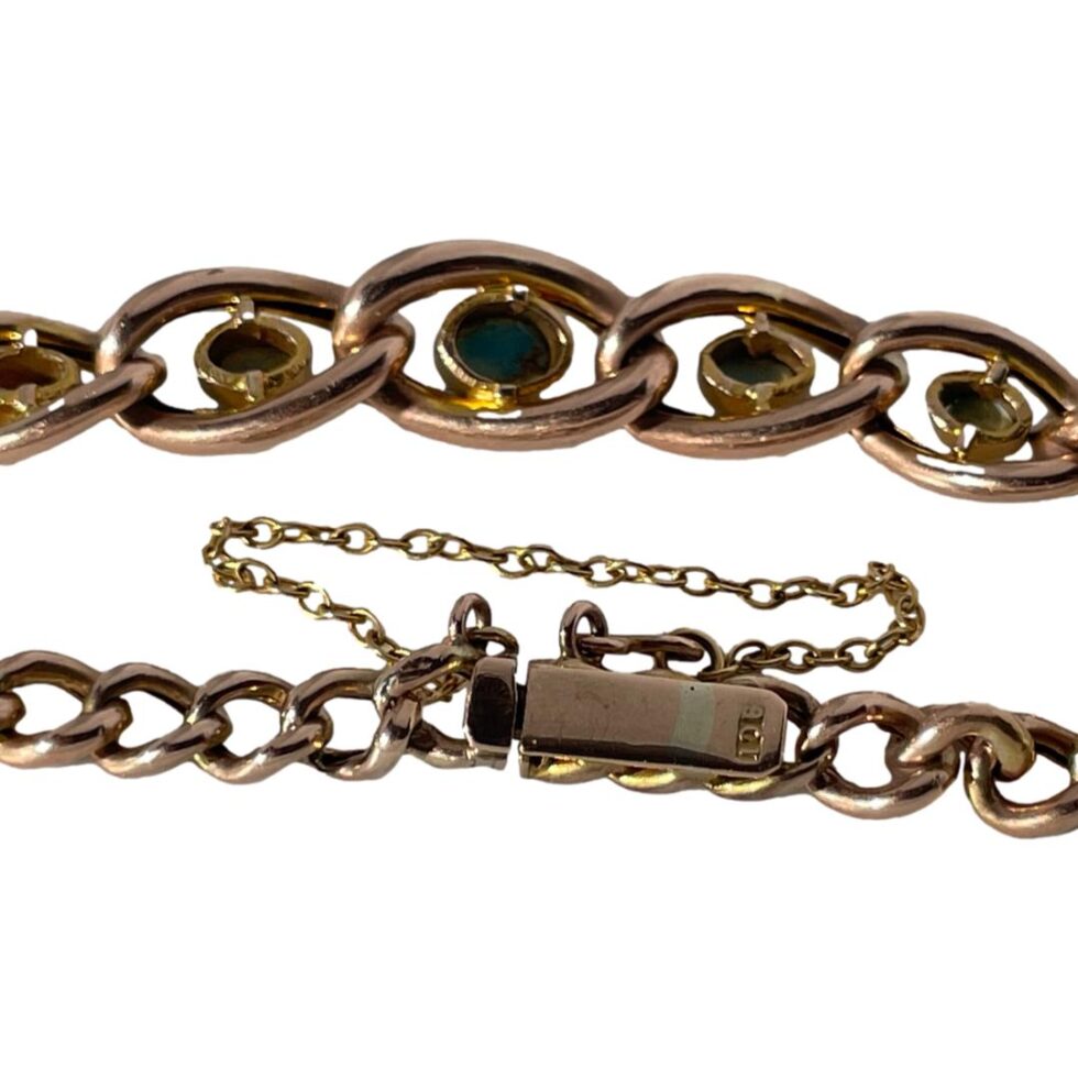 A close up photo of the 9ct hallmark on the back of the clasp and the back of the 5 chain links housing the turquoise stones. The clasp is shown closed.