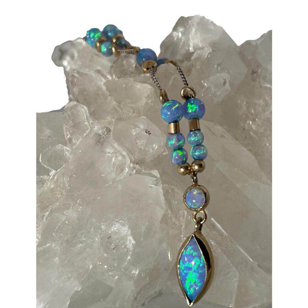 A close look at the black opal front area of the necklace whichis still draped over the quartz crystal.