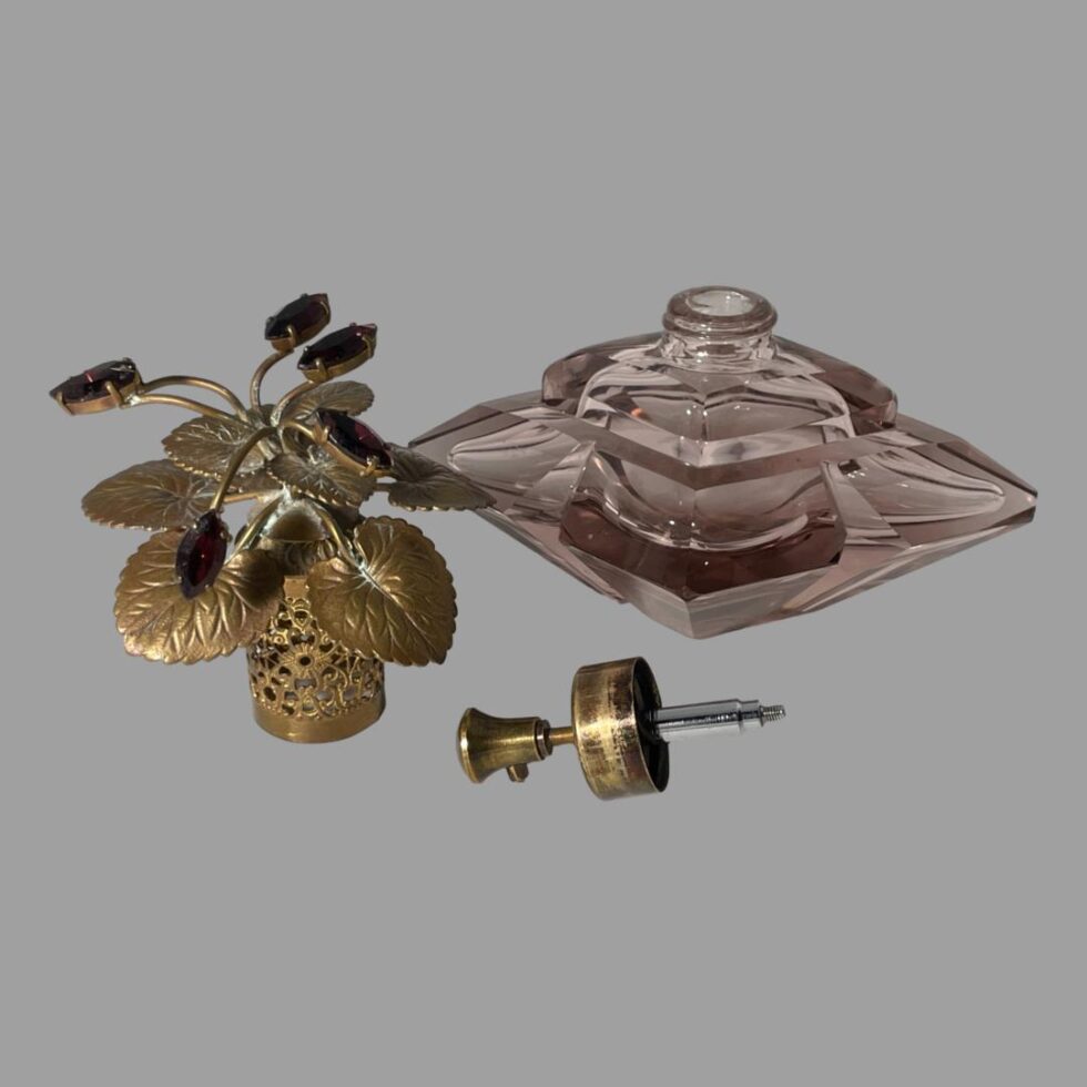 Photo of Irice scent bottle with lid and pump nozzle removed. The pump nozzle is in the centre foreground, the kid upright on the left and the bottle is set a little back and on the right.