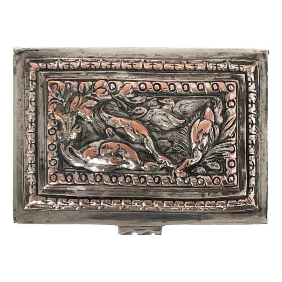Photo looking straight down at the lid from above. The scene shows ducks on the water. 2 in the background facing left, 2 in the left foreground facing right and one appearing as though it has just splash landed in the water. The silverplate wear is quite extensive here with a lot of copper on show again, wear adds another dimensional quality to an already exquisite piece.