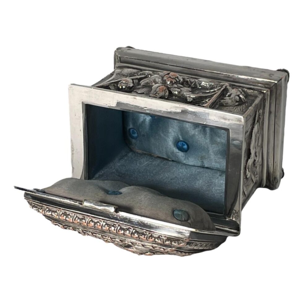 Photo of casket laid open with the lid in the left foreground. The lid is quite top heavy and will topple the casket over . The goats head mark is visible reflecting on the inside rim of the box.