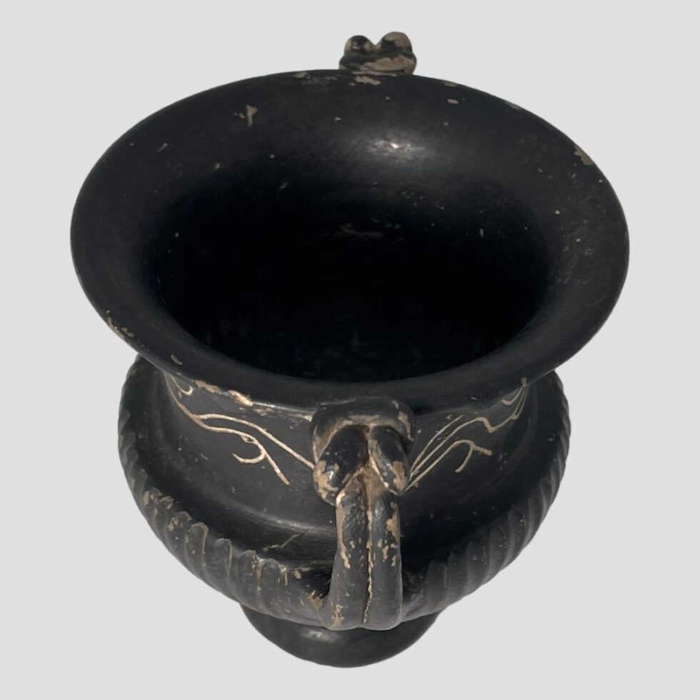 Photo of small urn this time with the handles to centre top and bottom. We can see well into the interior of the urn which is also matt black.
