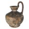 Main photo of Roman shipwreck wine jug displayed on a plain white background and seen from an eye level. The jug has a bulbous lower body for the wine, a short neck and a rounded mouth. The single handle is attached to one end of the mouth, rises upward then curves straight down to sit above the upper bulbous area of body. The jug has a lovely patina with some fossilisation along the bottom.