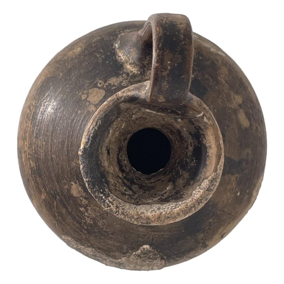 Photo of Roman wine jug looking straight down at the top into the mouth. The handle is at centre top.