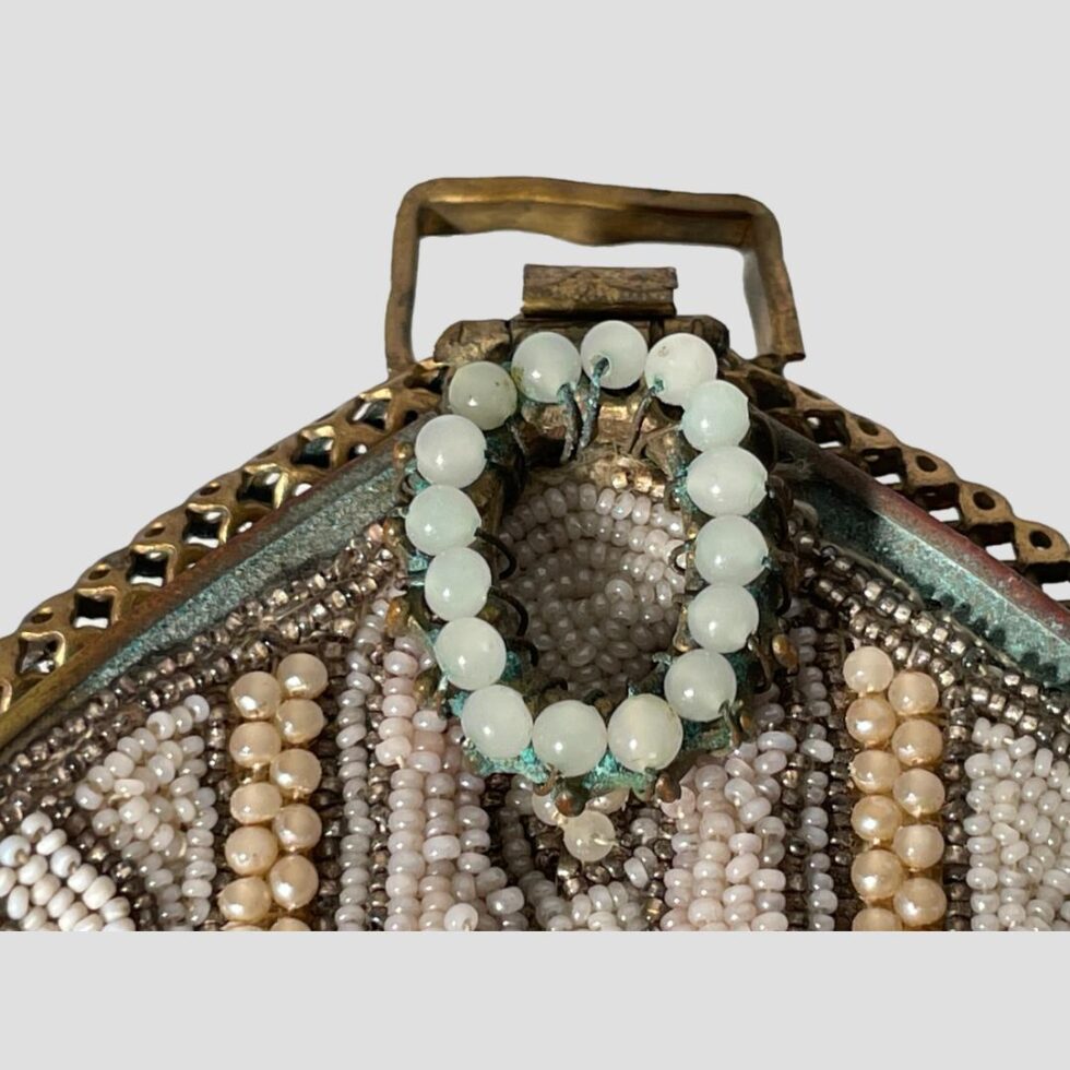Close up photo of the small circular pale green beaded clasp. Some of the corrosion is visible here.