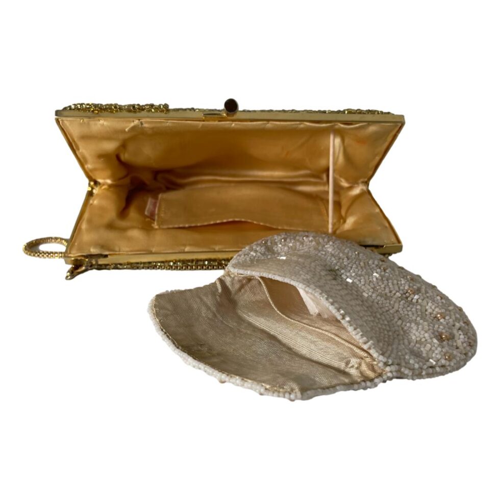Photo of gold bag laid on a flat surface and shown propped open by a stick. The small purse is in the fore ground also shown open. The small purse front has small shimmering white beads with a few gold coloured beads. It has 2 sections inside and is missing a clasp.