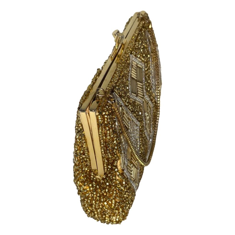 Photo looking down at vintage gold beaded bag with one of the thinner sides just off centre foreground to the left showing the depth of the bag. The frame does not shut tight with a small gap at the end but closes tight.