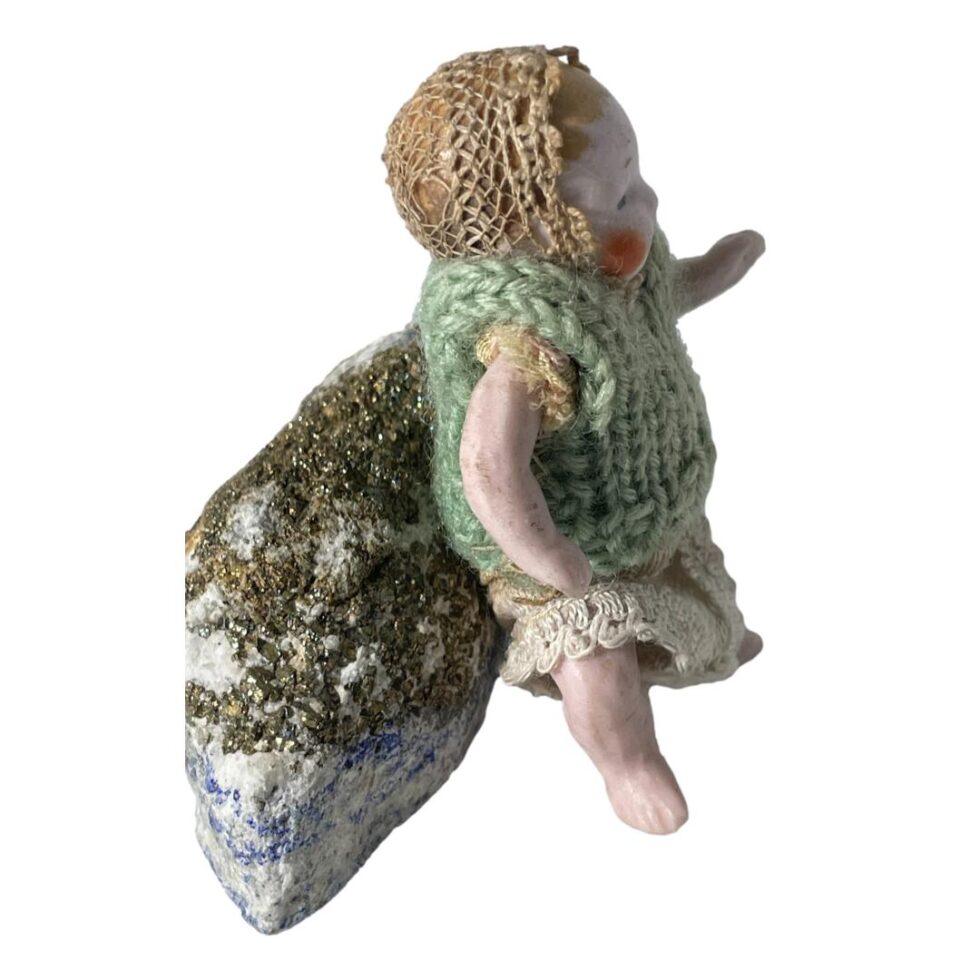 The German bisque doll is still leaning against a rock and this time seen from a side view with doll facing right.