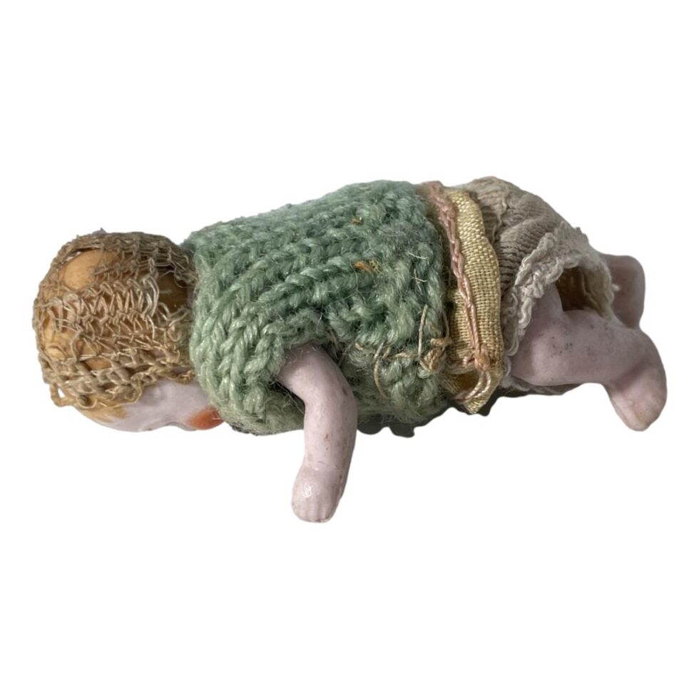 Photo of bisque doll face down with head on the left.