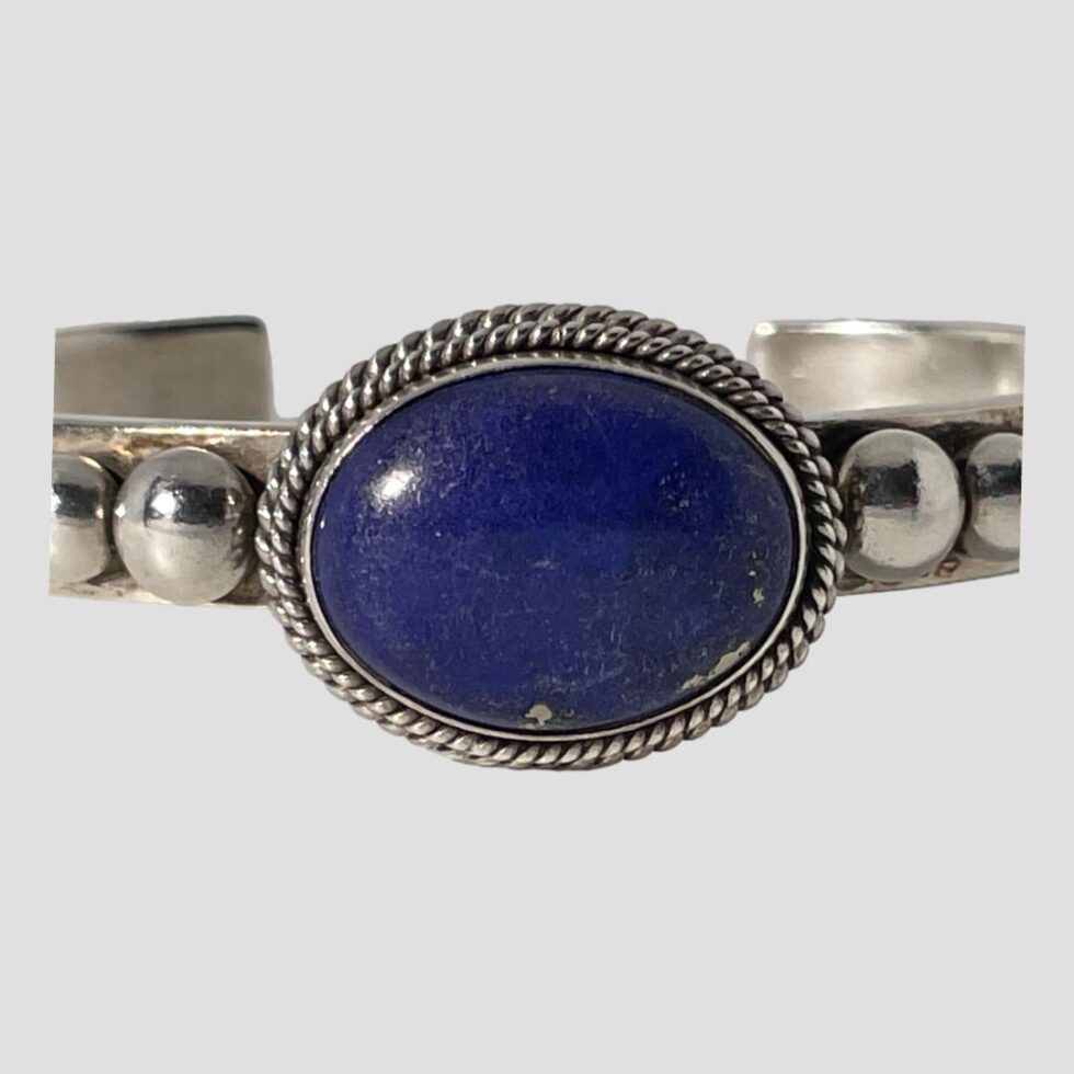 A very close up photo of the lapis area of the cuff bracelet with part of shoulder and balls included in the shot.