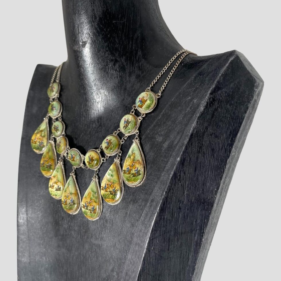 Photo of Persian necklace still displayed on a black wooden stand with the necklace front this time facing slightly to the side and facing towards the bottom left.
