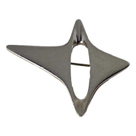 Main photo of Georg Jensen Star brooch displayed with the longest side of this 4 pointed abstract star displayed horizontally across the page and the shorted points vertical. This abstract star has one point which is longer than the other 3 and is on the left side here. To the right is a short wide point. The 2 vertical points sit above and below an oblong gap in the brooch where you can see the pin behind. The abstract shape seems to give a sense of movement like a falling star.