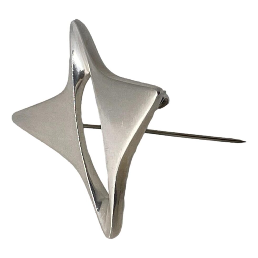 Photo of the star brooch displayed from a side angle with the pin propping up the brooch.