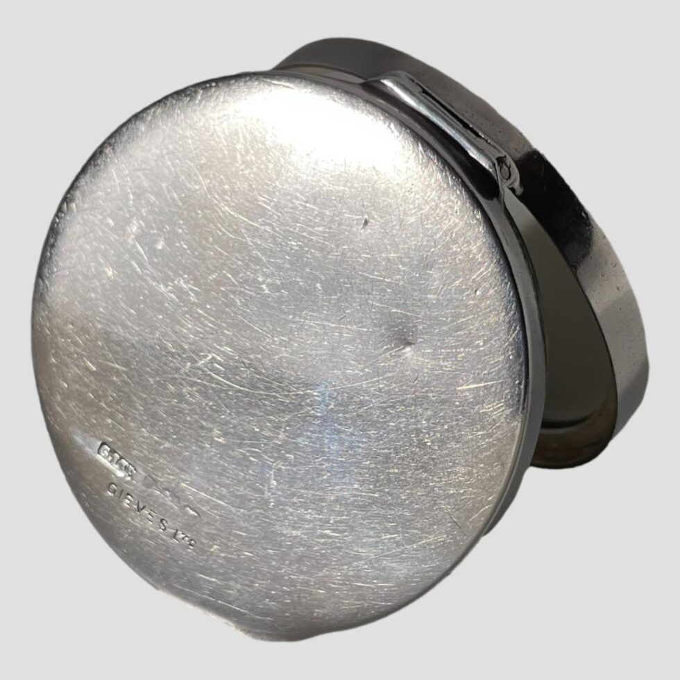 Photo of the base of the blue enamel compact with the hallmark and makers name just visible to the bottom left.