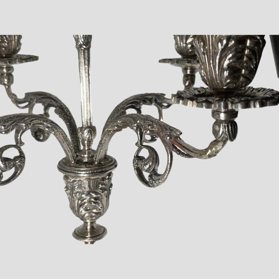 A close up of the design detail of a few of the candelabrums arms and the central sconce where the column and arms extend from.