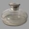 Main photo of antique silver mounted inkwell seen from an almost eye level raised very slightly to see a little of the crest on the top. The glass well has a lovely bulbous shape and flat base giving it a ships decanter type look except bulbous from the neck. The silver top is flip open with a silver neck which covers the top and inside rim.
